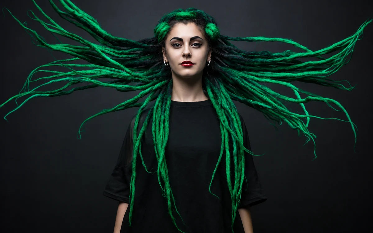 Grüne Dreadlocks, aufgefächert vor dunklem Hintergrund